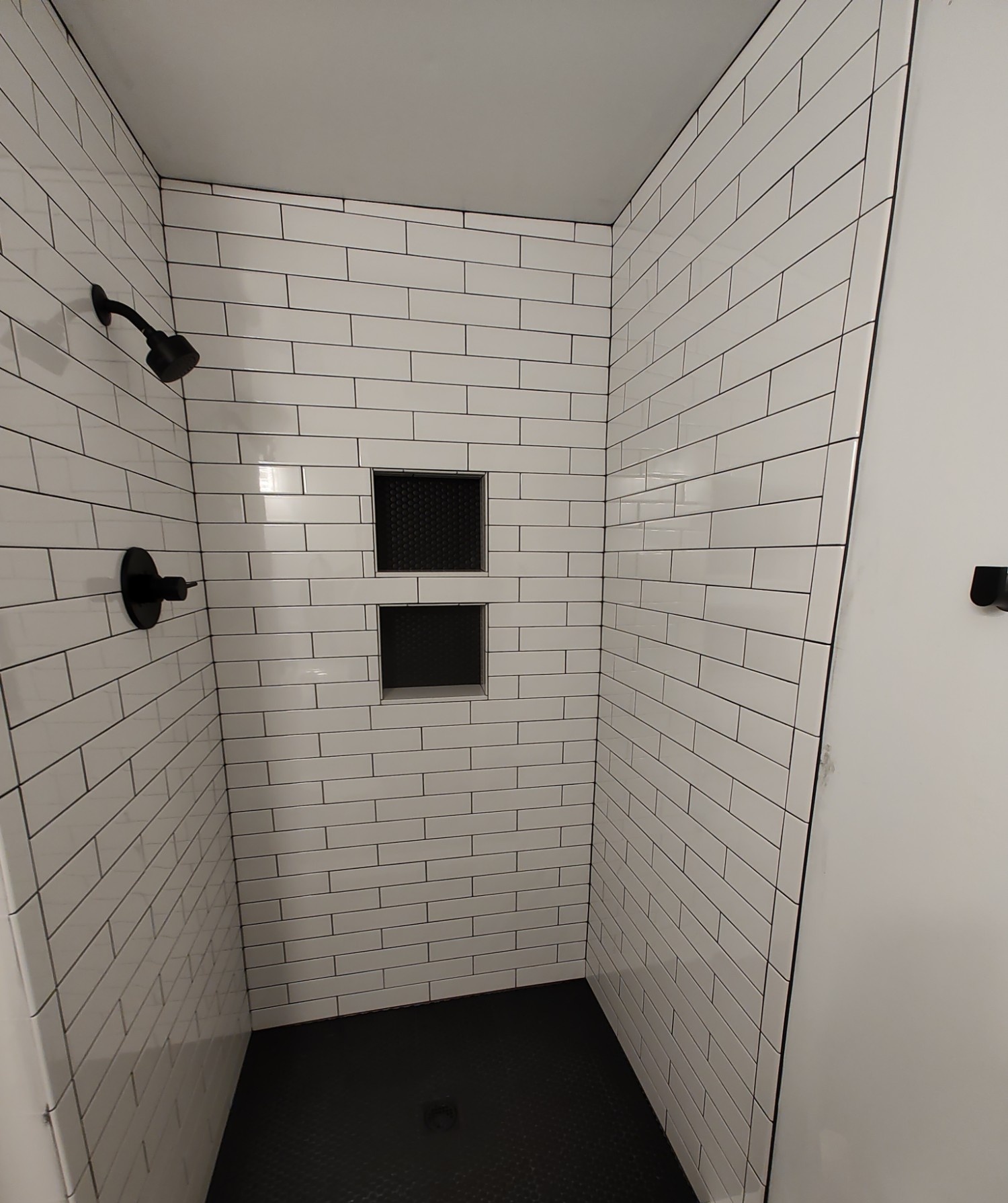 White subway tile shower with a tiled niche