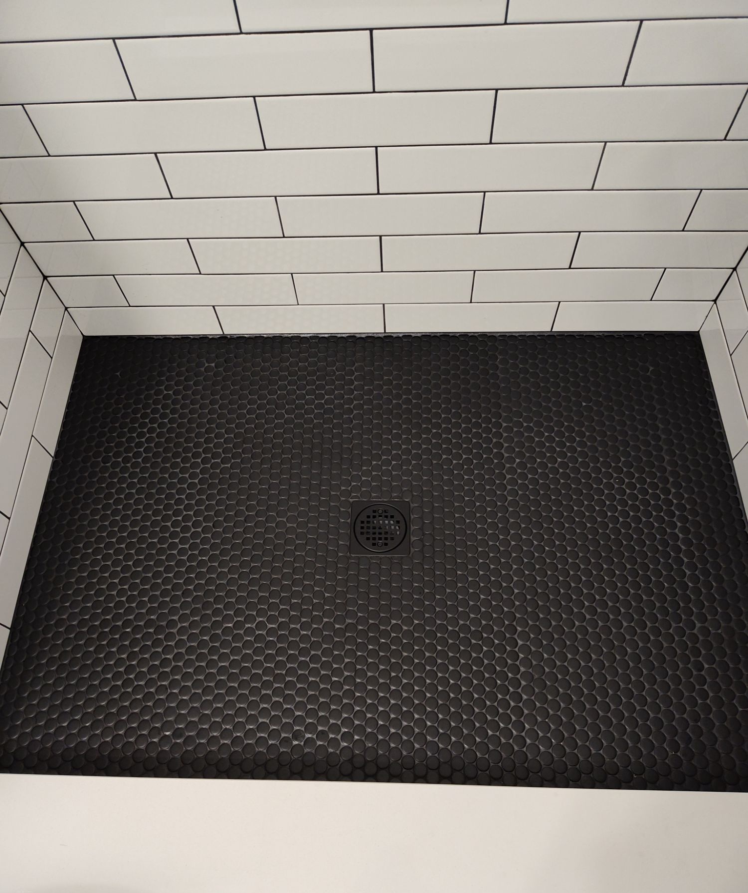 Black penny tile shower floor