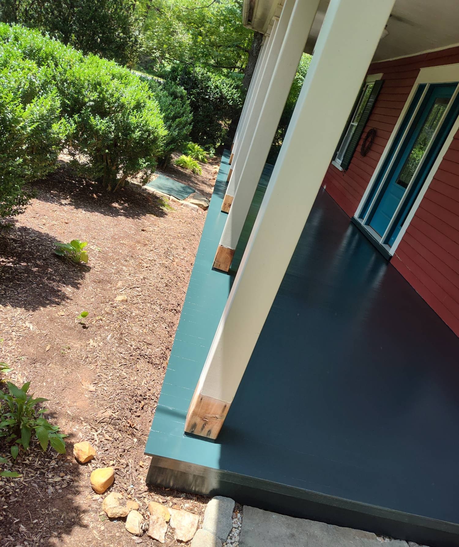Freshly painted porch floor detail in teal and navy