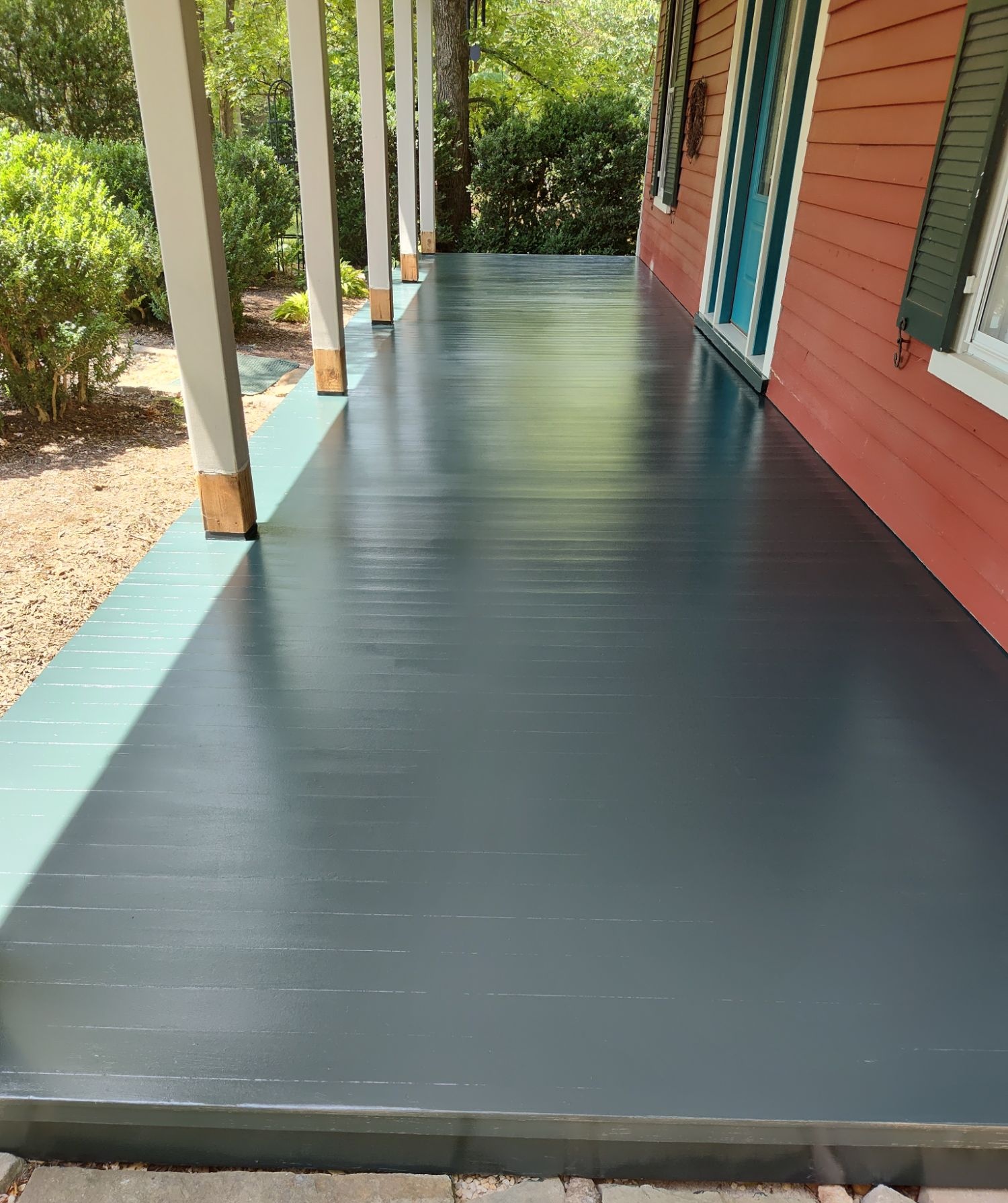 Long painted front porch in deep teal and navy