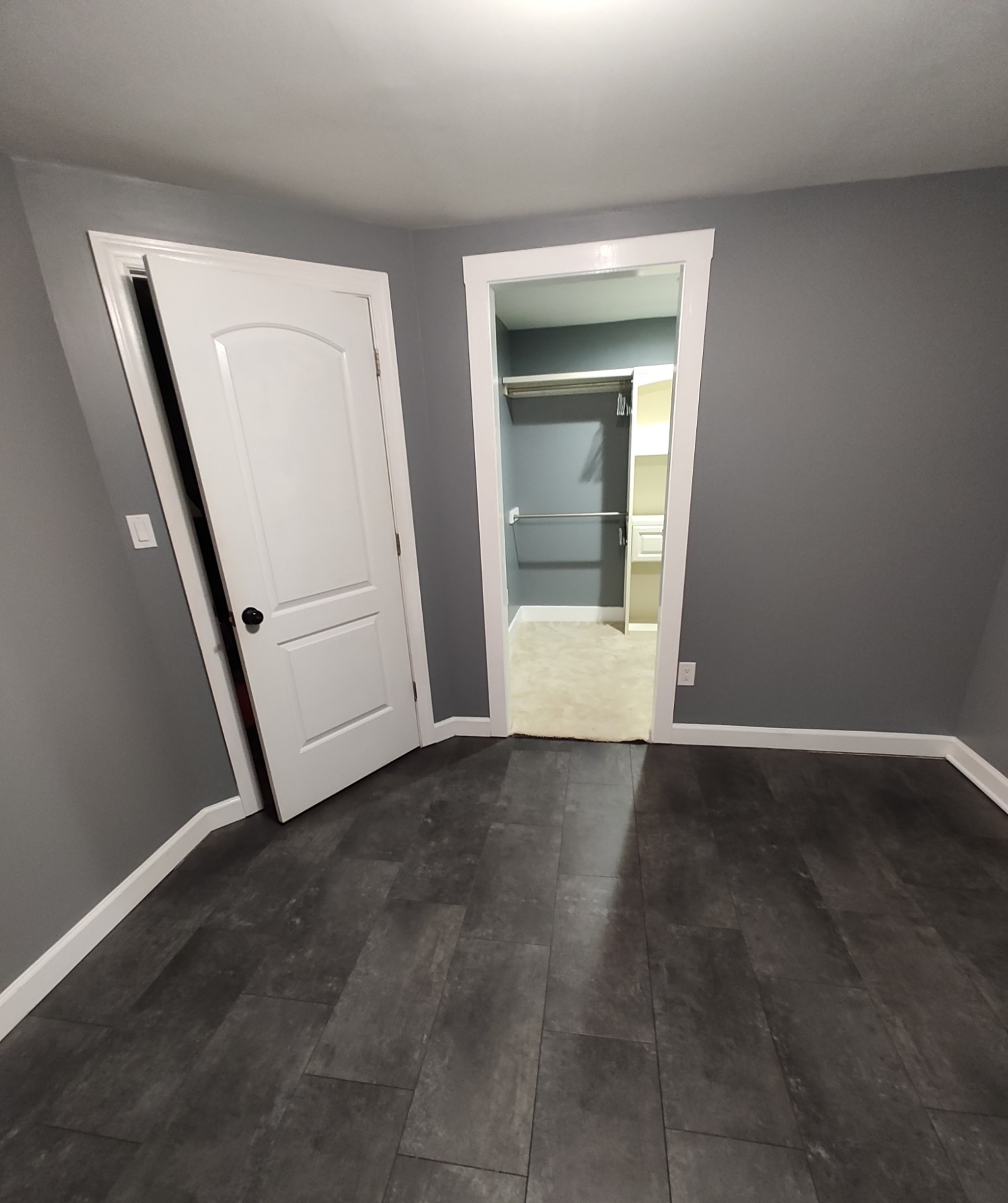 Empty room finished with dark tile flooring