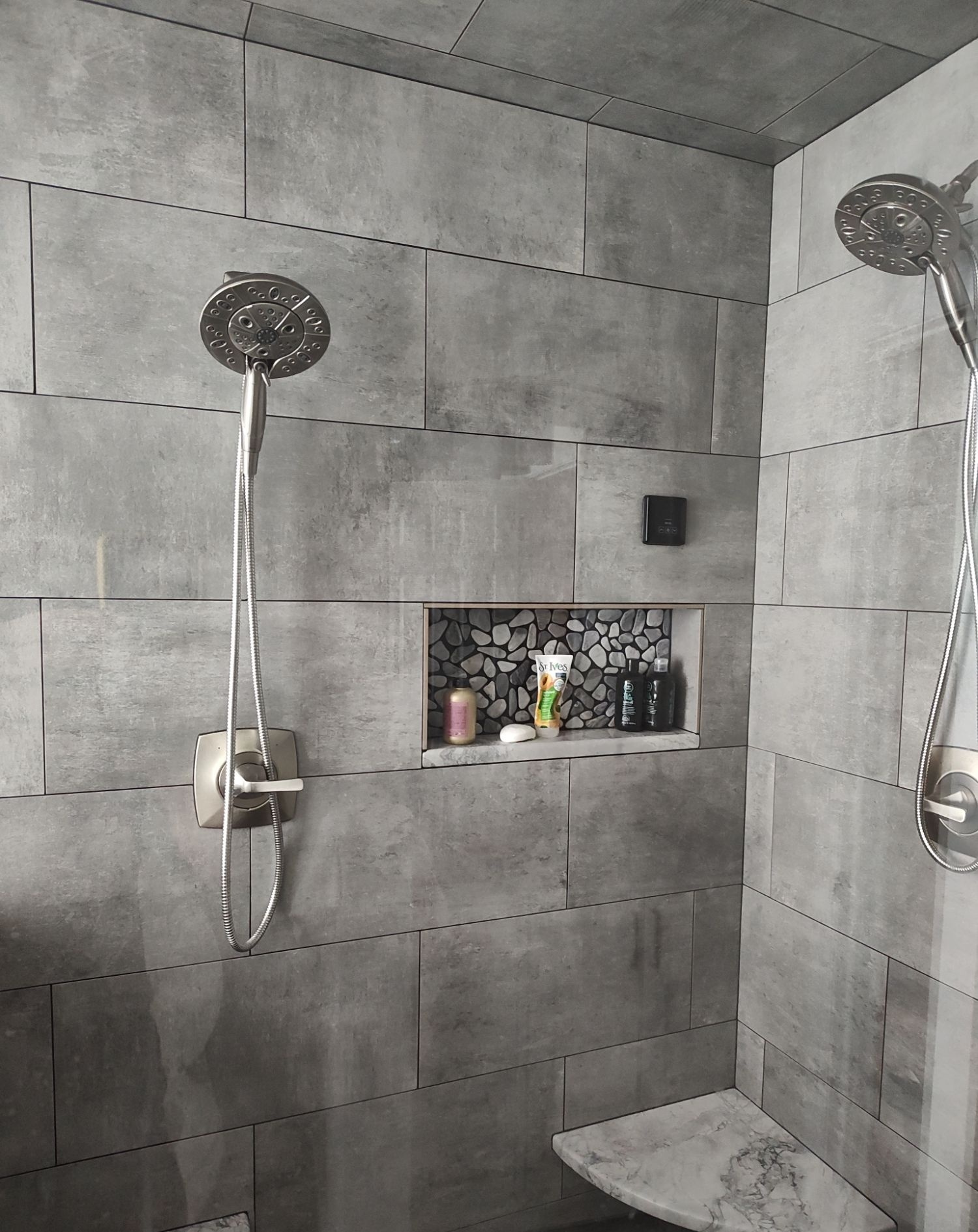 Dual shower heads with a stocked tiled niche