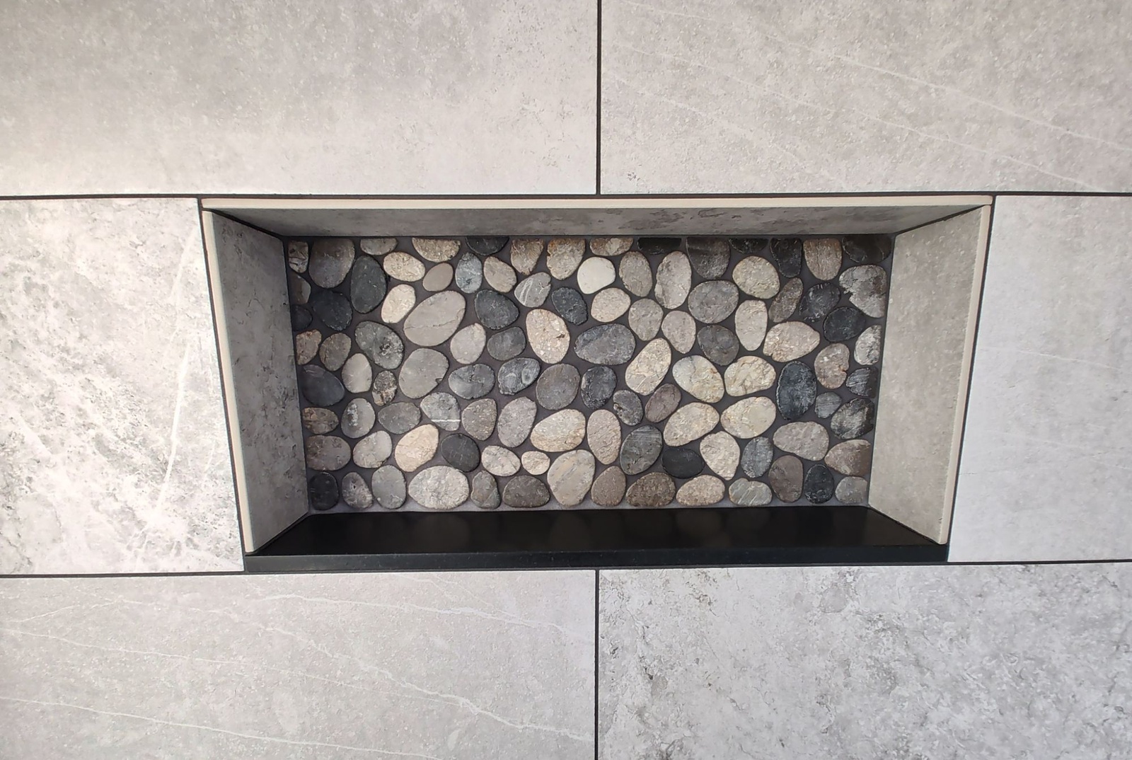 Close-up of a river pebble tile niche