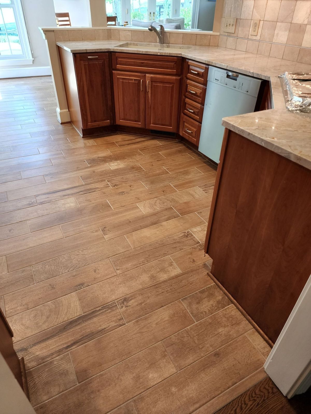Corner kitchen sink cabinetry with tile countertop and backsplash