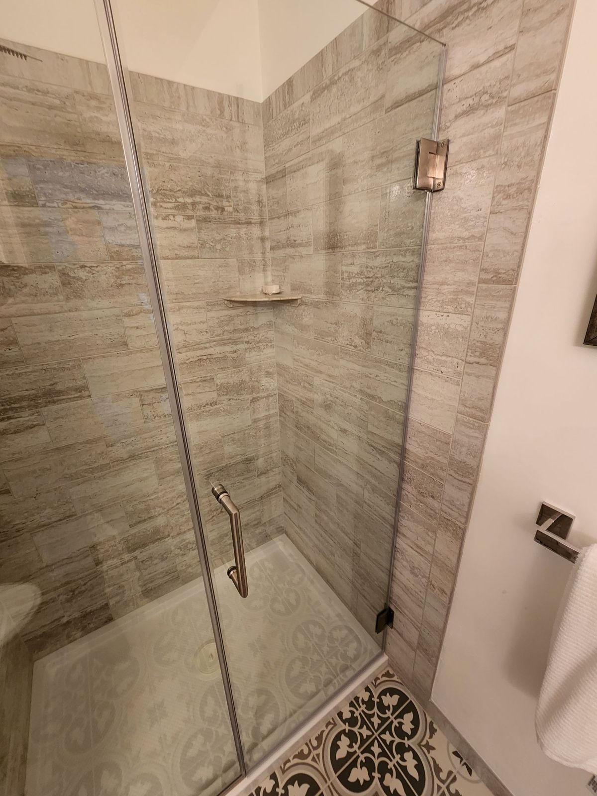 Close-up of brushed nickel shower door handle and hardware