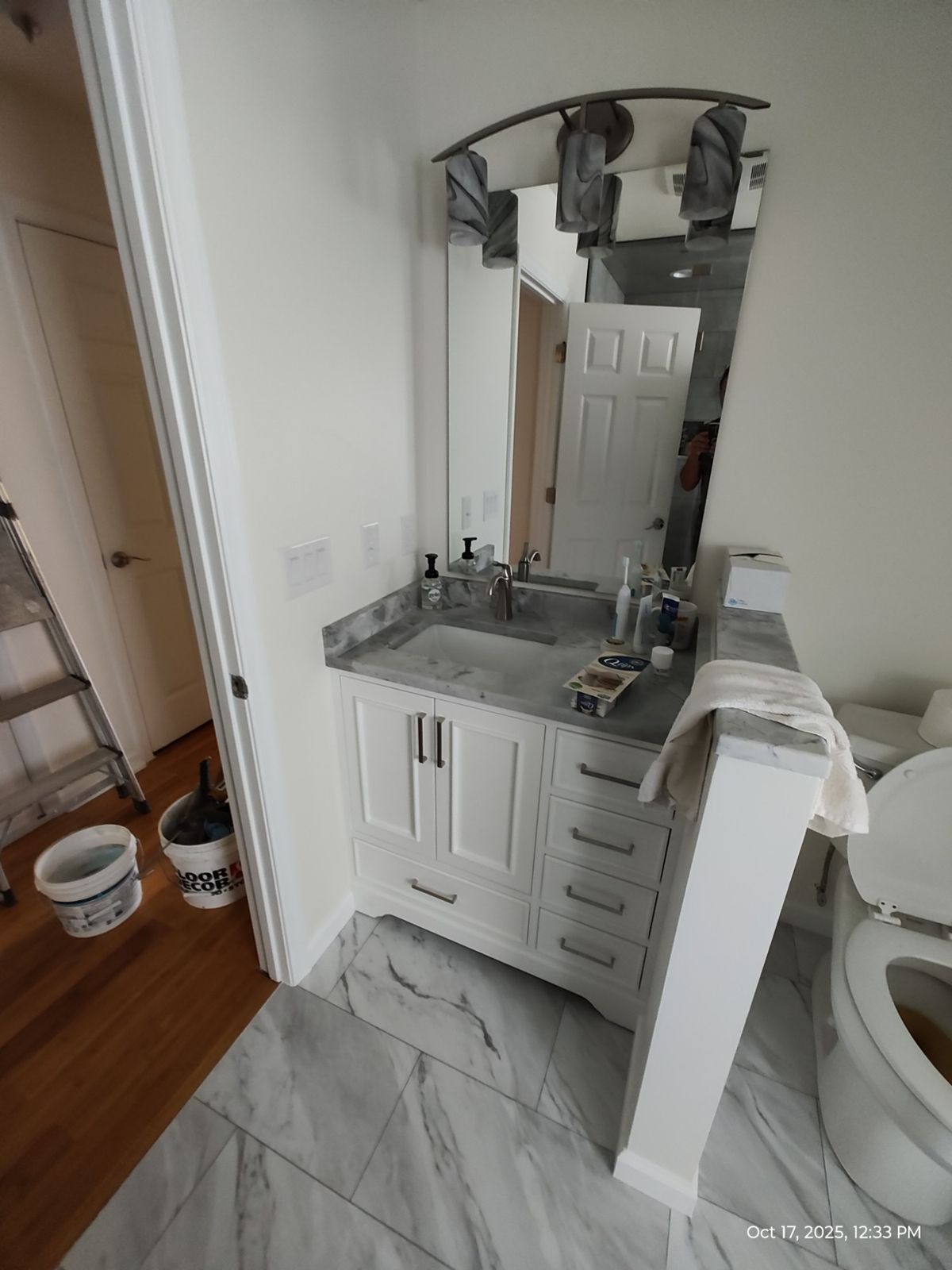 White bathroom vanity with marble-look countertop and mirror