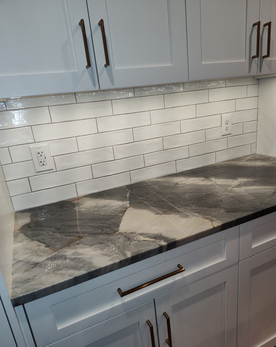 Kitchen backsplash and waterfall marble-look countertop with brass hardware